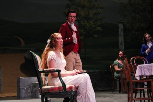 Clarissa Kepner performs during Pride & Prejudice dress rehearsal. Mason Gottshall performs in the background.